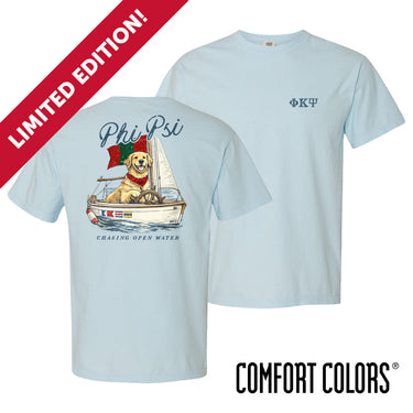 Light blue Comfort Colors t-shirt shown front and back; front features small Greek letters on the left chest, back displays a golden retriever sailing a boat with script text above and “Chasing Open Water” below.
