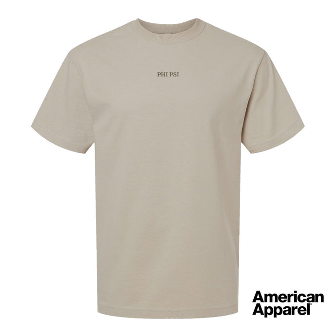 Beige short sleeve crewneck t-shirt with small embroidered text at the center chest on a clean background.